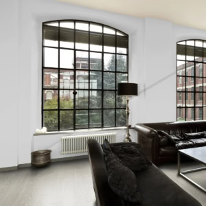 Modern living room with large arched windows and leather sofa